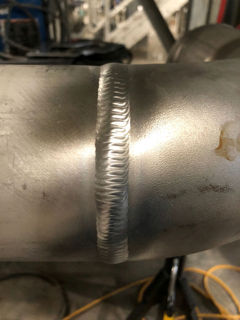 Uniform stainless weld bead running across a fitted pipe joint